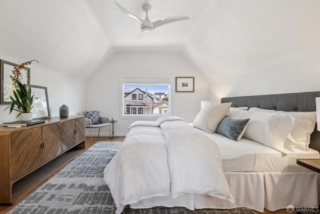 a spacious bedroom with a bed a couch and a window