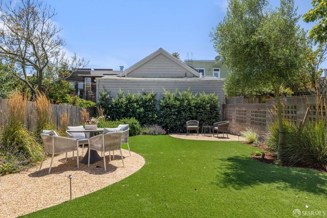 a view of a house with backyard sitting area and garden