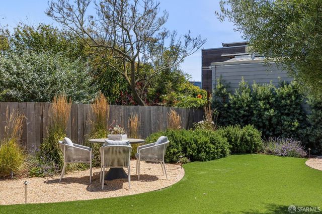 a view of a chair and table in backyard of the house