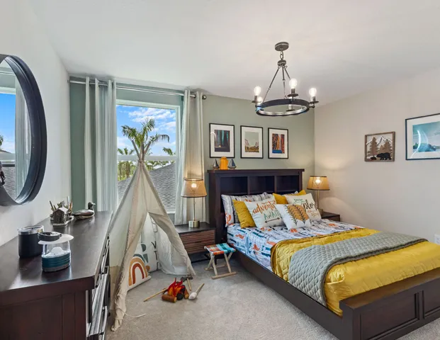 a bedroom with bed and a chandelier