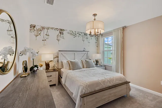 a bedroom with a large bed and a chandelier