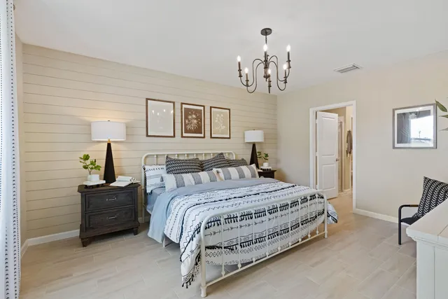 a bedroom with a bed and a chandelier