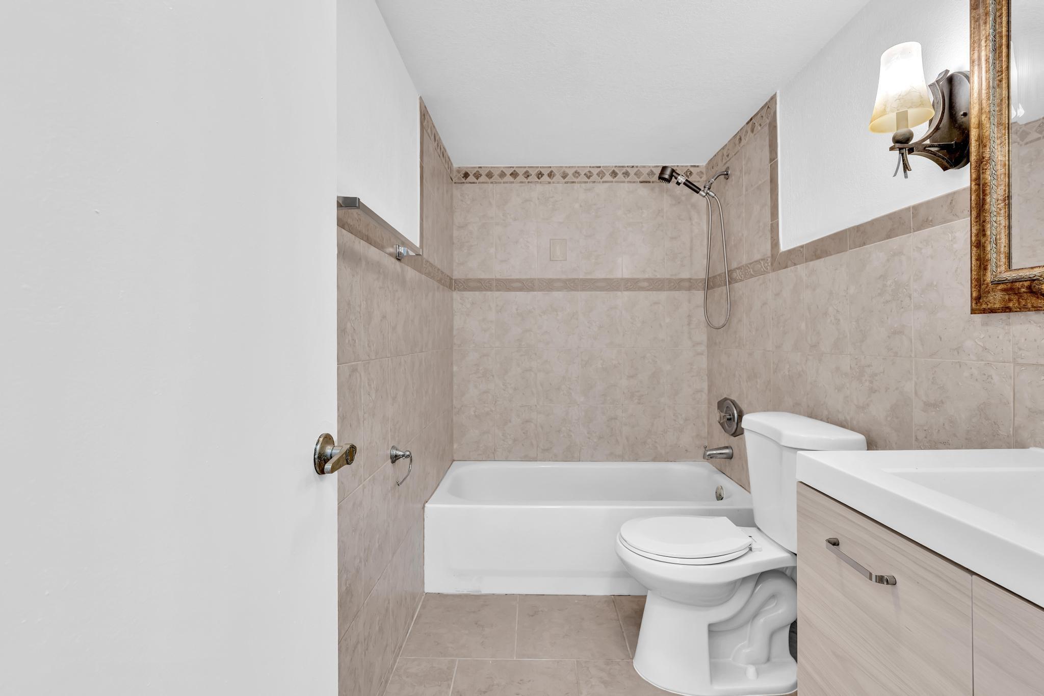 1291 Northwest 13th Street, Unit 445D Boca Raton, FL 33486 - Photo 39 of 50 a bathroom with a toilet and a shower