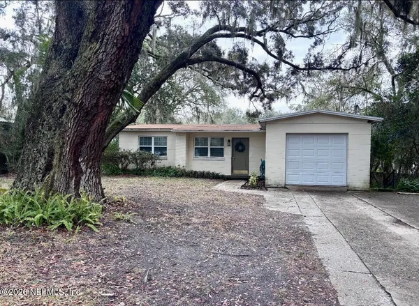 a front view of a house with a garden and trees