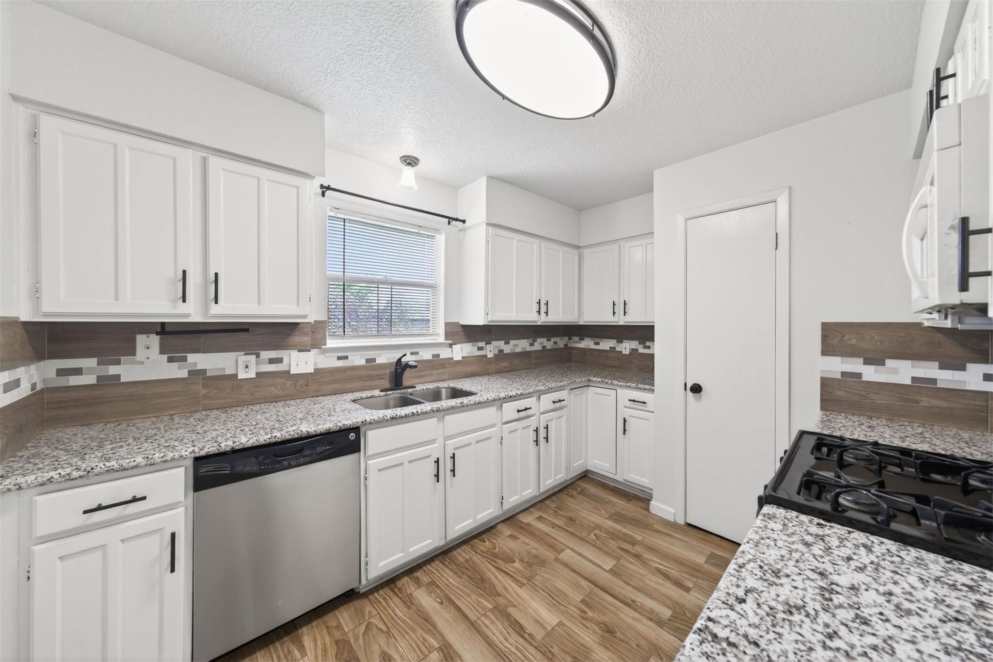 17002 Dew Drop Lane Houston, TX 77095 - Photo 6 of 24 a kitchen with granite countertop a sink cabinets and stainless steel appliances