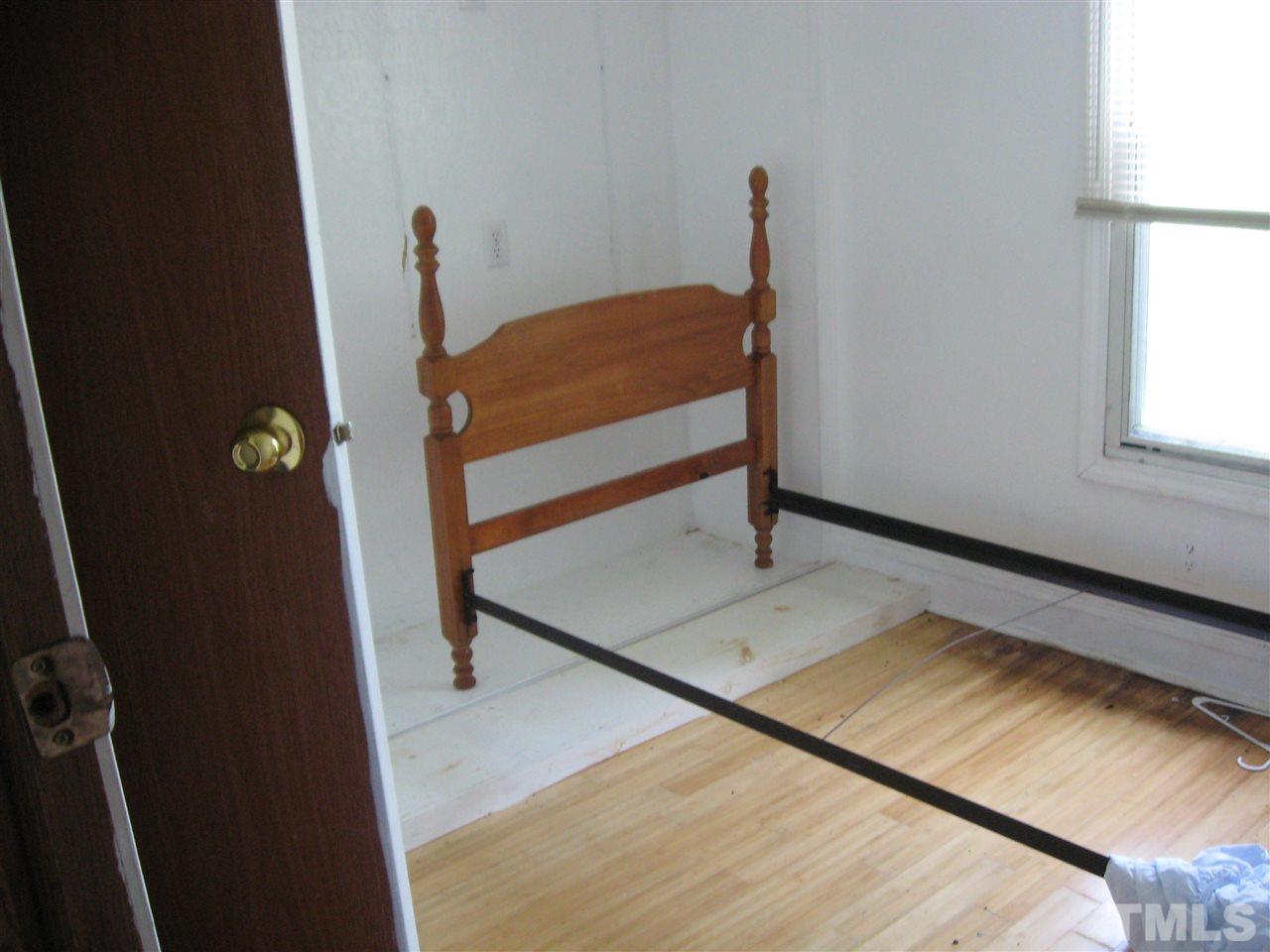 Hall bedroom has twin bed frame in it.