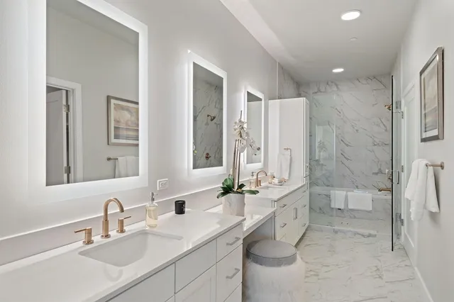 a bathroom with a double vanity sink mirror double and shower