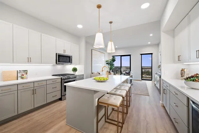 a kitchen with kitchen island granite countertop wooden cabinets and white appliances