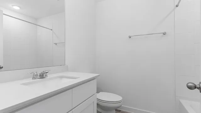 a bathroom with a granite countertop sink toilet and a mirror
