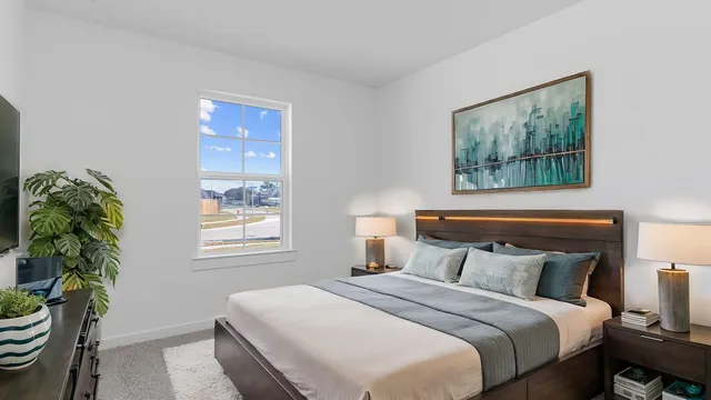 a bedroom with bed and a painting on the wall