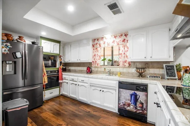 a kitchen with stainless steel appliances a sink cabinets and a refrigerator