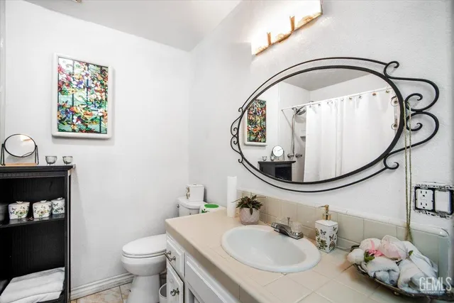 a bathroom with a sink and mirror with toilet