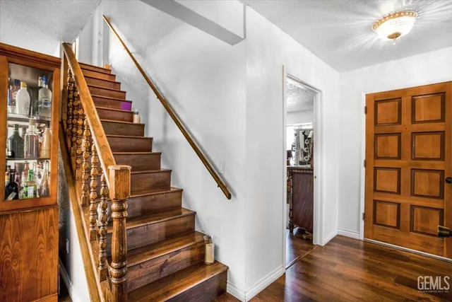 a view of staircase with lots of frames on wall and a potted plant
