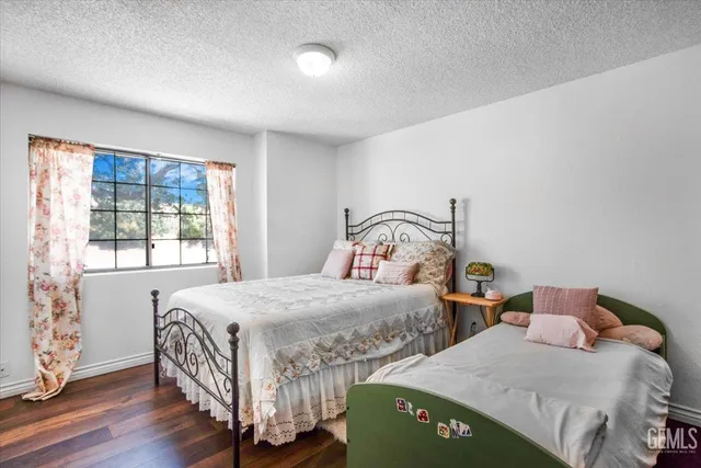 a bedroom with two beds and wooden floor