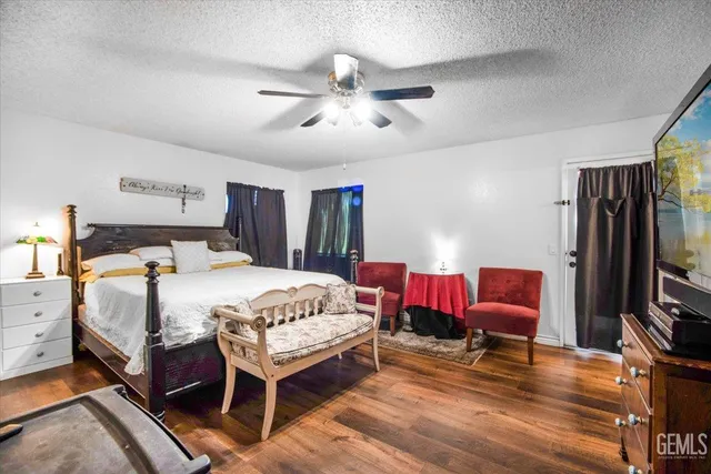 a spacious bedroom with a bed and a flat screen tv