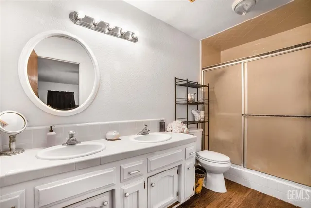 a bathroom with a granite countertop sink toilet and shower
