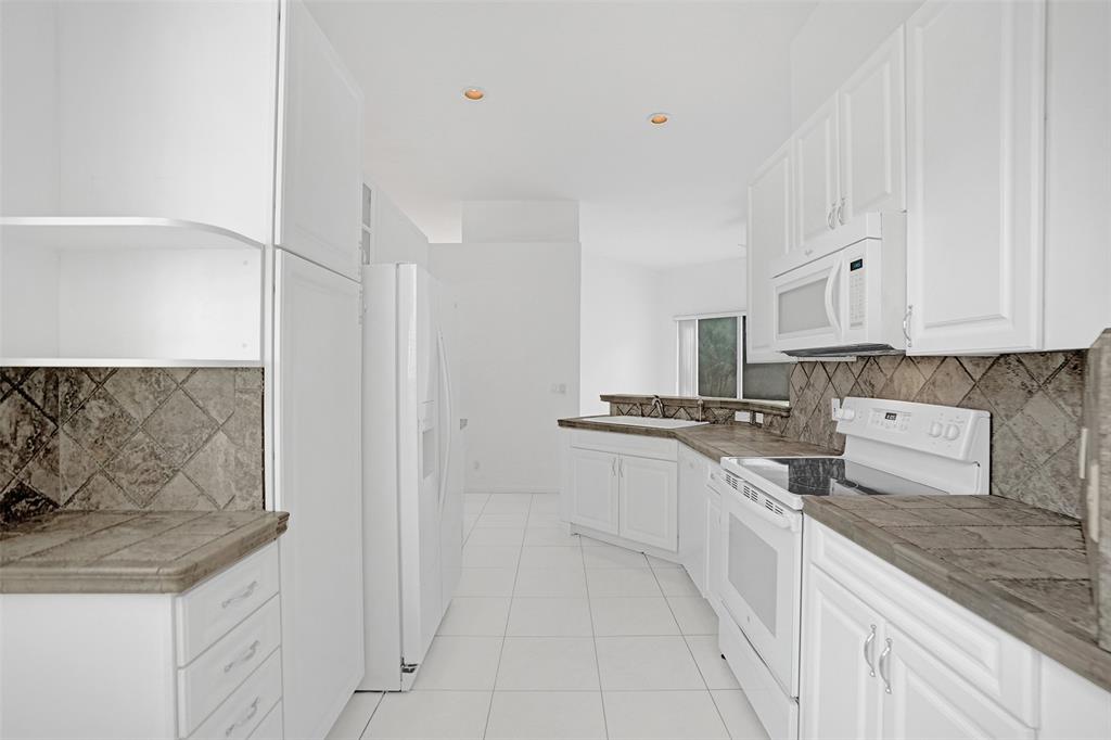 6463 Colomera Drive Boca Raton, FL 33433 - Photo 10 of 29 a kitchen with stainless steel appliances granite countertop a sink and cabinets