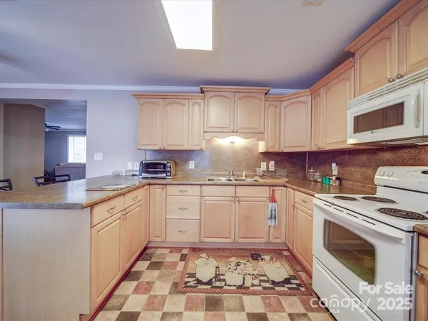 a kitchen with stainless steel appliances granite countertop a sink stove top oven and cabinets