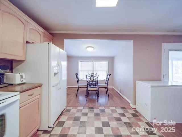 a kitchen with a table chairs and a refrigerator