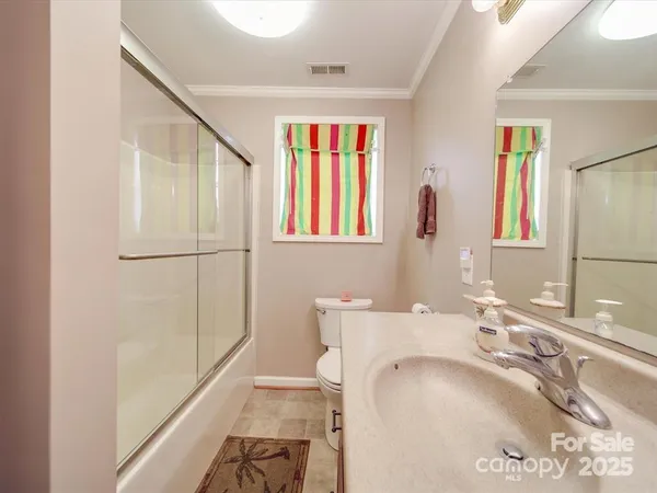 a bathroom with a granite countertop sink a mirror and a shower