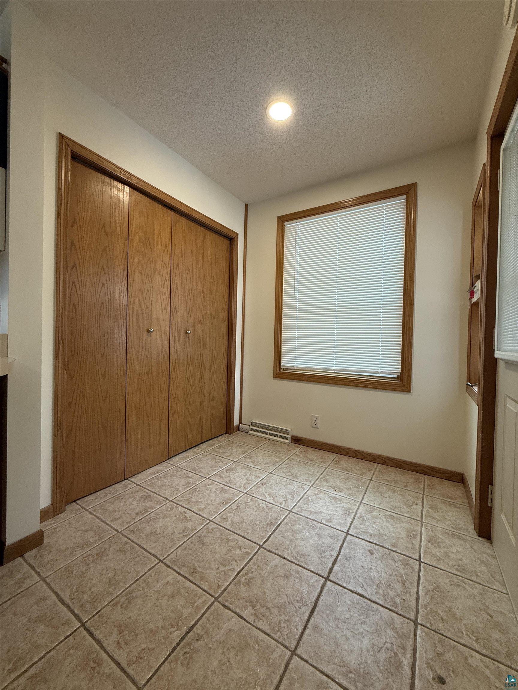 1321 South 13th Street Virginia, MN 55792 - Photo 8 of 33 Unfurnished bedroom with a textured ceiling, a closet, light tile patterned floors, and recessed lighting
