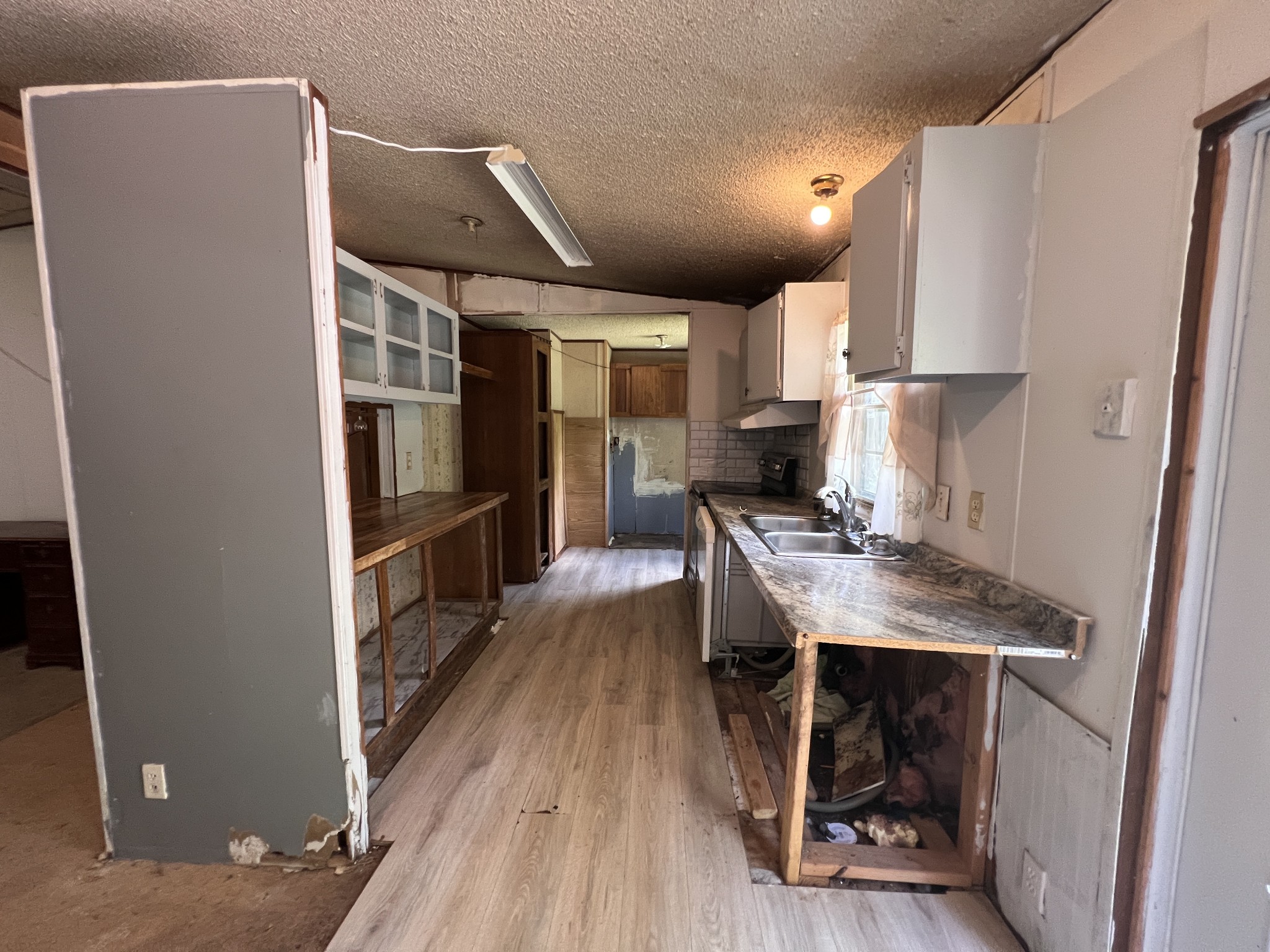 616 Powell Street Paris, TN 38242 - Photo 11 of 26 a kitchen with stainless steel appliances a refrigerator a sink dishwasher and a stove with wooden floor