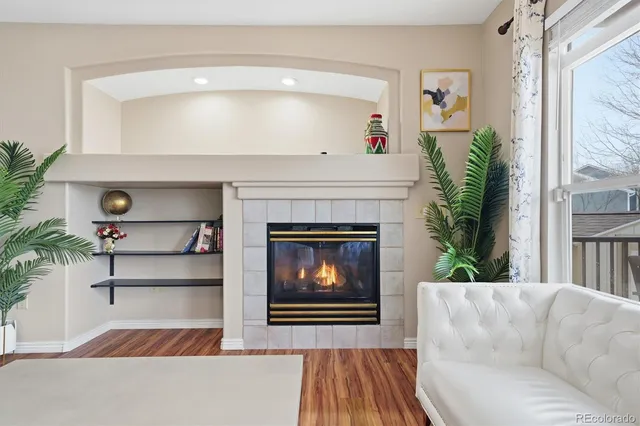 a living room with a fireplace and a potted plant