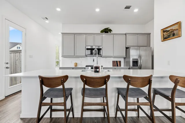 a kitchen with a dining table chairs and white cabinets