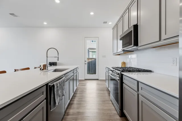 a living room with furniture kitchen view and a chandelier