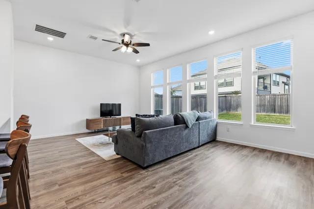 a view of a kitchen from the hallway with a wooden floor and a window