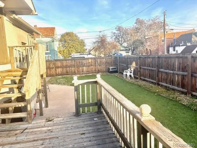 a view of a deck with a big yard and large trees