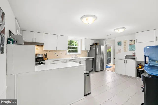 a kitchen with a refrigerator and a stove top oven