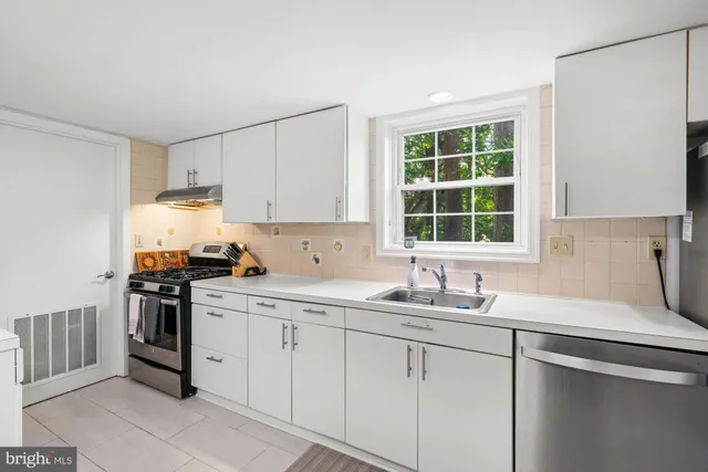 a kitchen with a sink window and stainless steel appliances