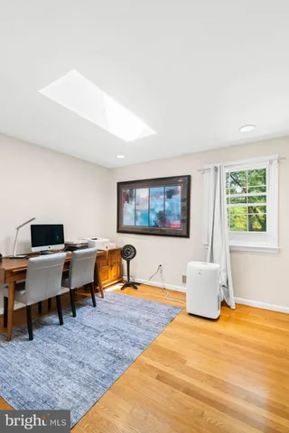 a bedroom with a bed a large window with table and chairs