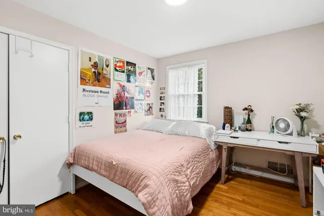 a bedroom with a bed and a flat tv screen on a dresser