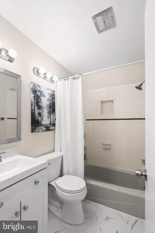 a bedroom with a bed and painting on the wall