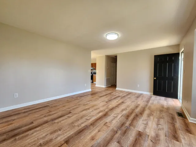 a view of an empty room and wooden floor
