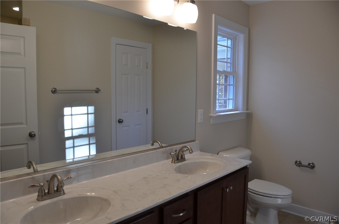 1118 Signboard Road Bumpass, VA 23024 - Photo 11 of 26 a bathroom with a granite countertop sink toilet and mirror