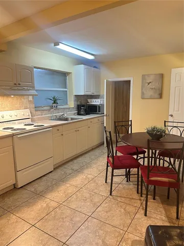 a kitchen with a dining table chairs and white cabinets
