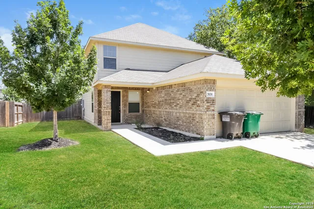 a view of a house with a yard and tree