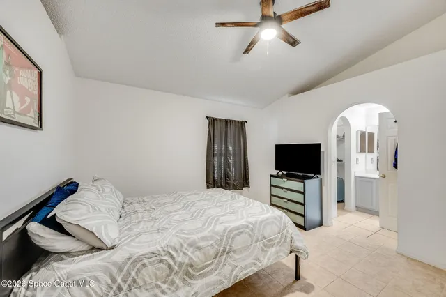 a bedroom with a bed and a flat tv screen on the dresser