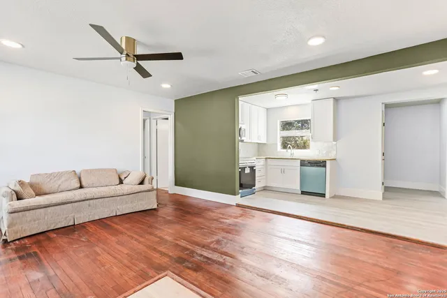 a living room with furniture and a ceiling fan