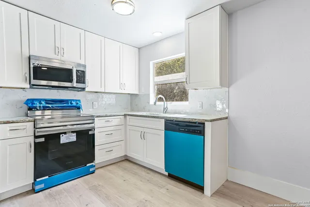 a kitchen with sink a microwave and cabinets