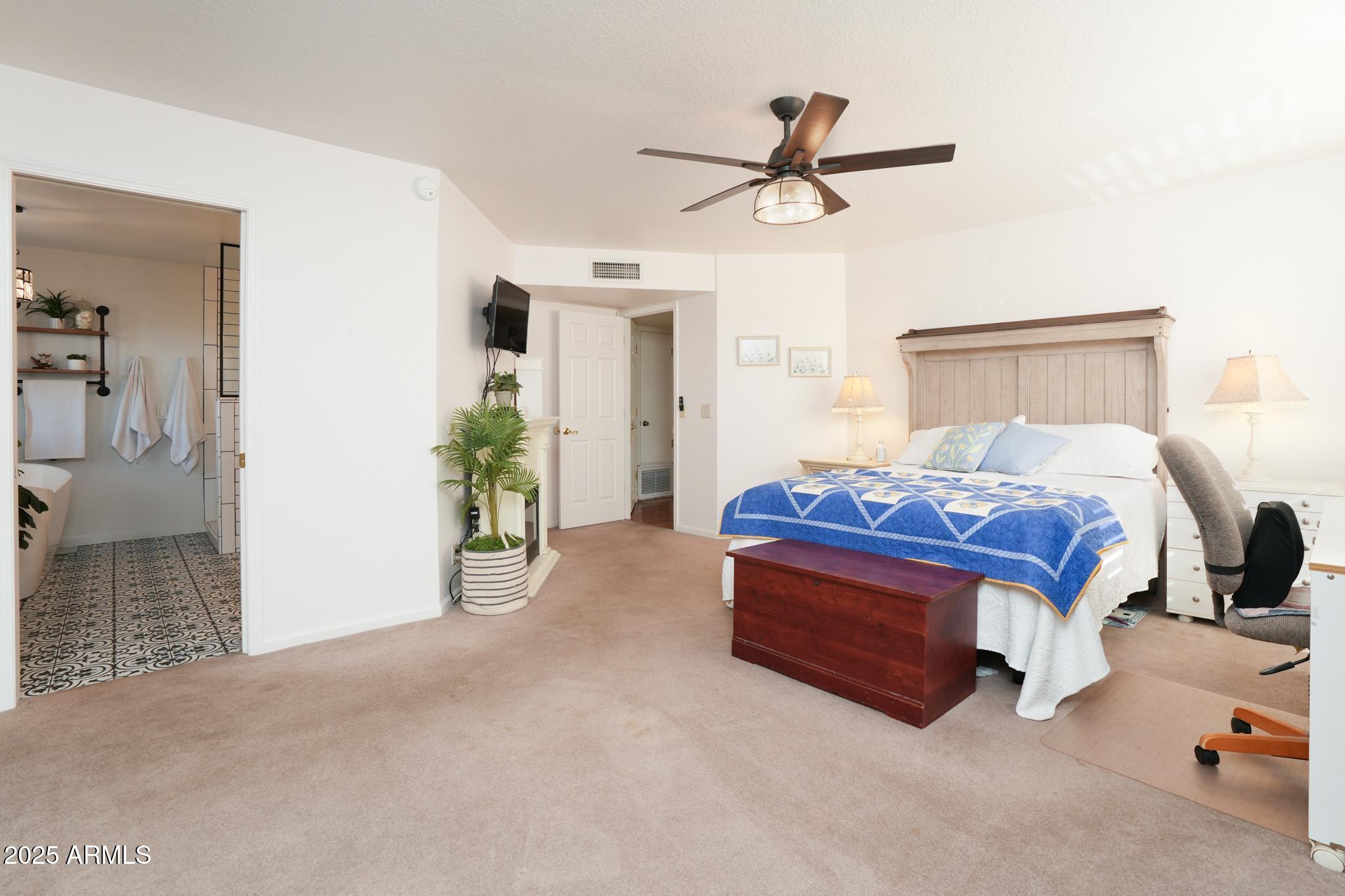 1665 Mountain View Road Cornville, AZ 86325 - Photo 19 of 46 a spacious bedroom with a bed and a chandelier