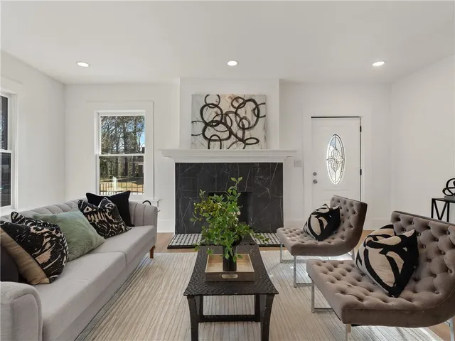 a living room with furniture kitchen view and a potted plant