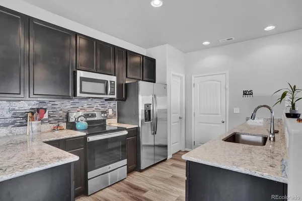 a kitchen with stainless steel appliances granite countertop a sink stove and refrigerator