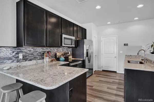 a kitchen with kitchen island granite countertop stainless steel appliances a sink stove and refrigerator