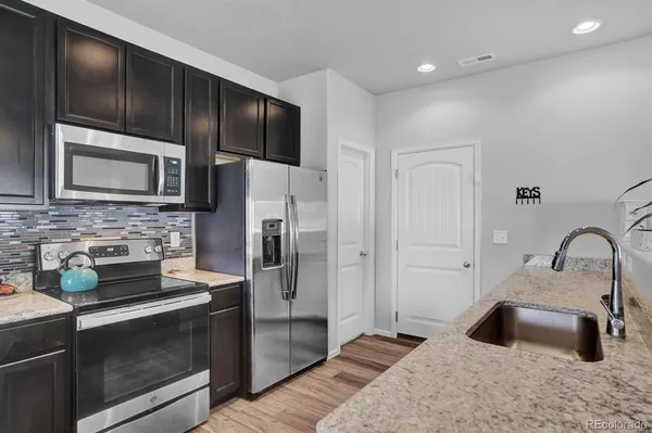 a kitchen with stainless steel appliances wooden cabinets a sink and a stove
