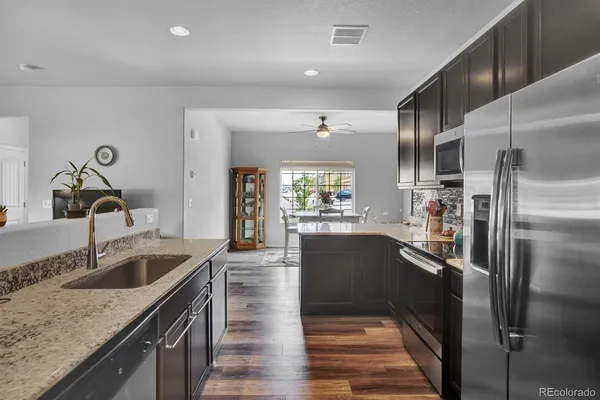 a kitchen with granite countertop a refrigerator and a sink
