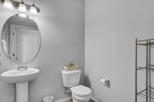 a bathroom with a toilet a sink and mirror